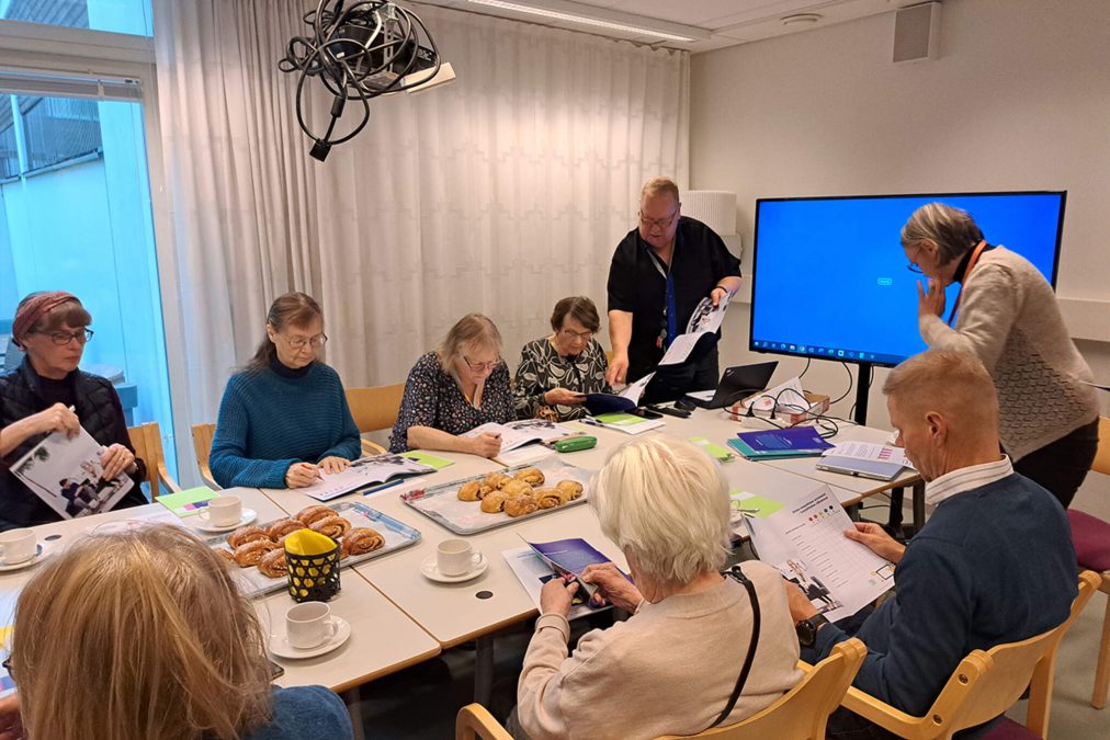 Senioreita Digiystävä-kurssilla yhteisen pöydän ääressä Töölön palvelukeskuksessa syksyllä 2023.